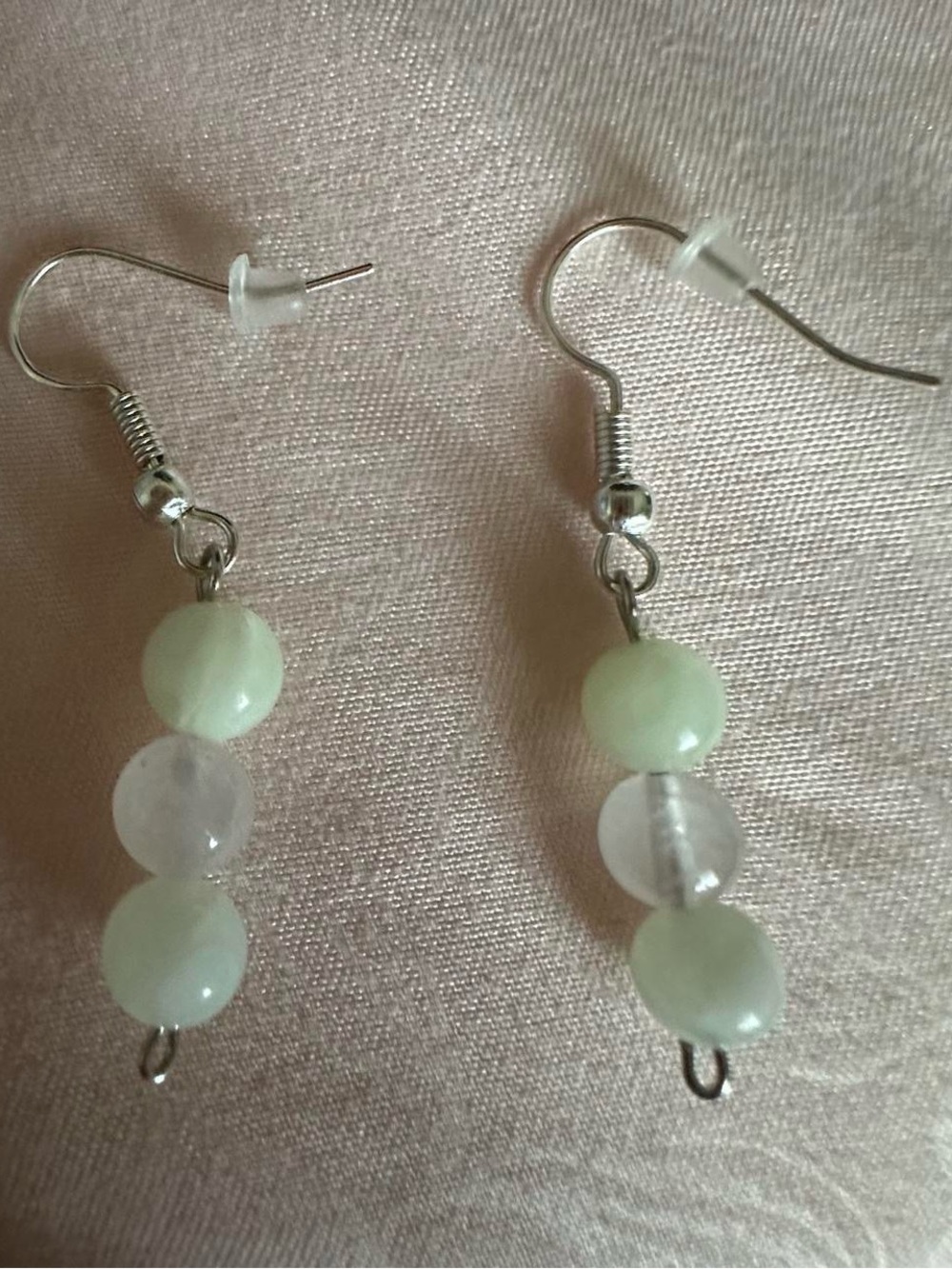 Elegant dangle earrings featuring pale green and translucent beads.